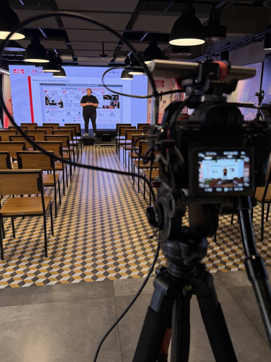 Câmera em tripé filmando uma palestra em um evento corporativo